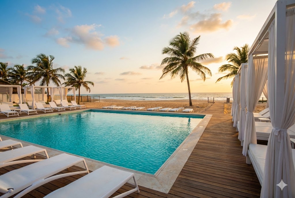 The Good Beach Victoria Island Lagos photography spot featuring turquoise swimming pool, white lounge chairs, and white cabanas with Atlantic Ocean in background during golden hour